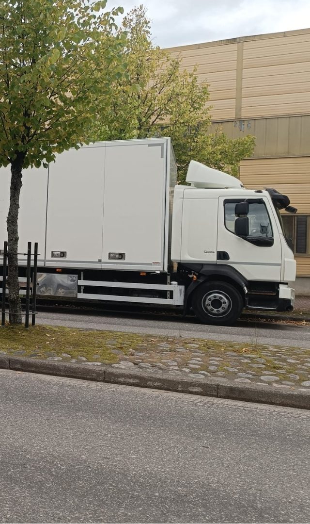 Valkoinen kuorma-auto pysäköitynä kadun varteen.